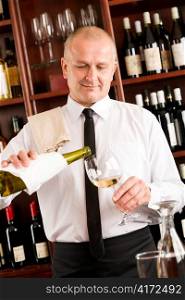 Wine bar happy waiter pour white wine in glass restaurant