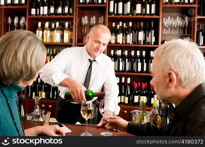 Wine bar senior couple enjoy drink professional barman pour glass