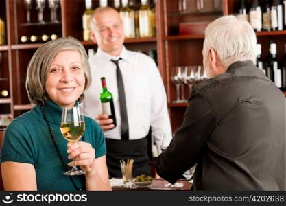 Wine bar senior couple enjoy drink smiling barman discussing