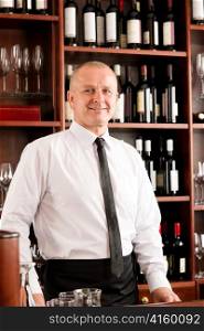 Wine bar waiter happy male in restaurant standing behind counter