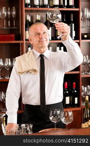 Wine bar waiter looking at clean glass in restaurant