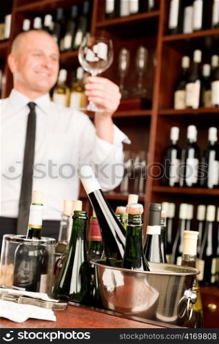 Wine bar waiter looking at clean glass in restaurant