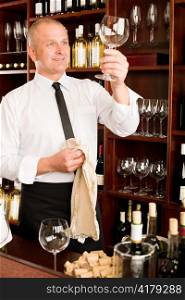 Wine bar waiter looking at clean glass in restaurant