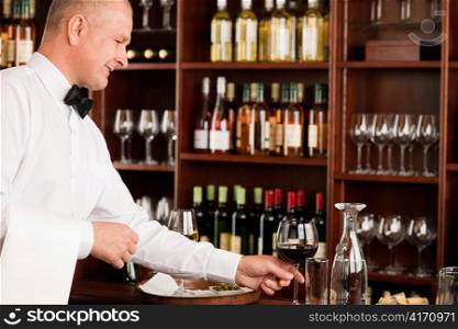 Wine bar waiter mature serving glass in restaurant