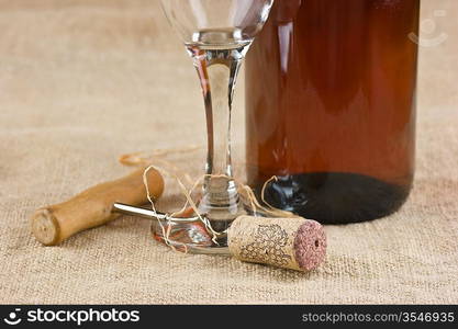 wine bottle and corkscrew on a canvas, still life