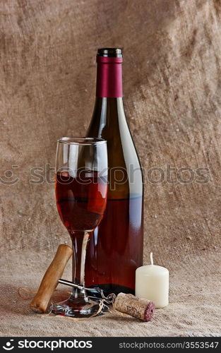 wine bottle and corkscrew on a canvas, still life