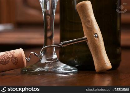 wine bottle and corkscrew on a wooden table