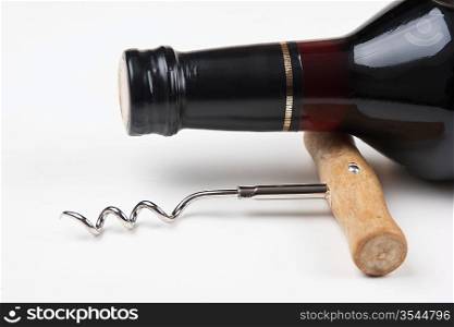 wine bottle and corkscrew on white background
