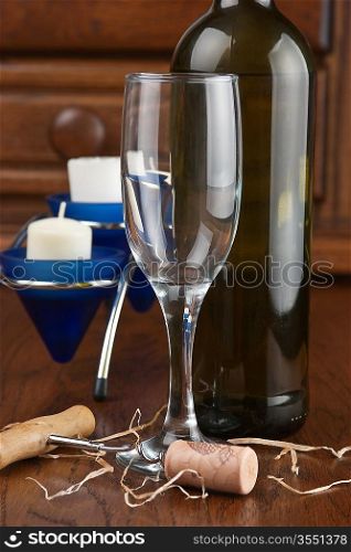 wine bottle and wineglass on a wooden table