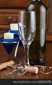 wine bottle and wineglass on a wooden table