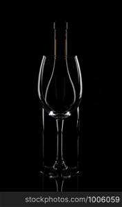 Wine bottle behind the wine glass, isolated on black.. Wine bottle behind the wine glass, isolated on black