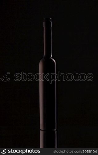 Wine bottle on a black background. Soft beautiful highlights on the bottle, with reflection.. Wine bottle on a black background. Soft beautiful highlights on the bottle.