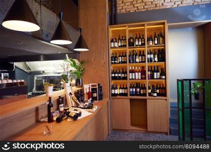 Wine bottles on a wooden shelf in modern restaurant interior