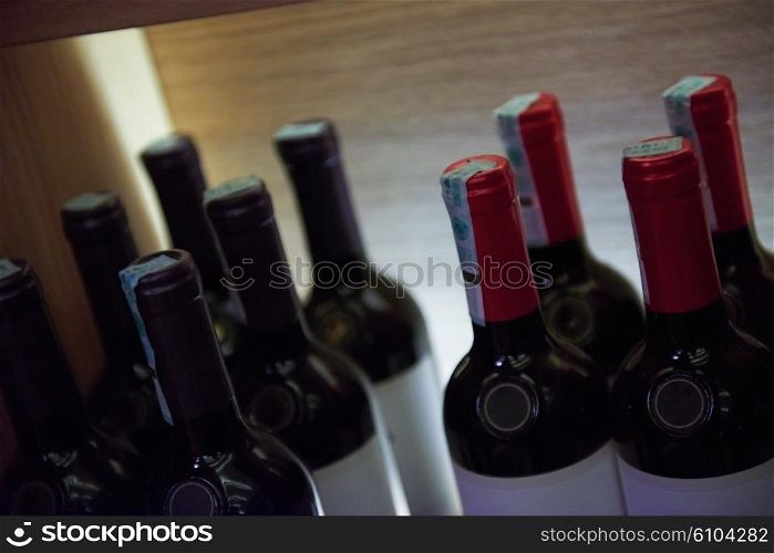 Wine bottles on a wooden shelf in modern restaurant interior