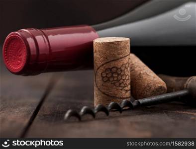 Wine cork with vintage corkscrew on wooden board background.