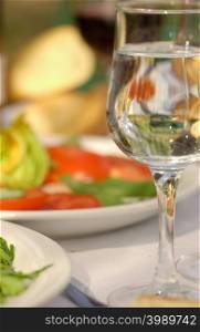 Wine glass by plate of tomatoes