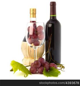 wine glass full with grapes and two wine bottles isolated on white background