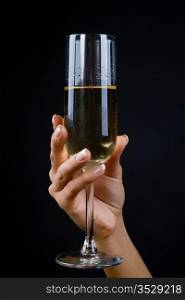 Wine glass in a hand of the girl on a black background