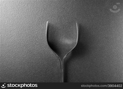 Wine glass made of forks on black background