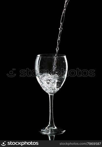 Wine glass with water over black background