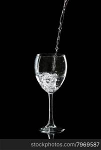 Wine glass with water over black background