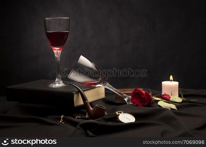 Wine glasses and candle, still life on a black background
