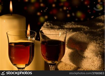 Wine glasses in candlelight and colored background lights.