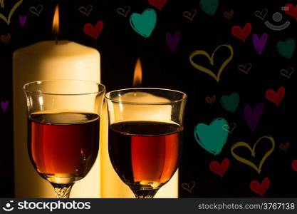 Wine glasses in candlelight with colored background hearts.