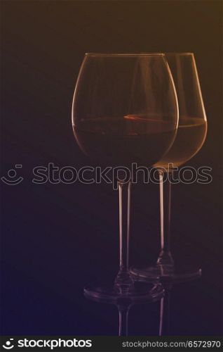 Wine glasses on black - two glasses of red and white wine, retro toned. Wine glasses on black
