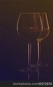 Wine glasses on black - two glasses of red and white wine, retro toned. Wine glasses on black