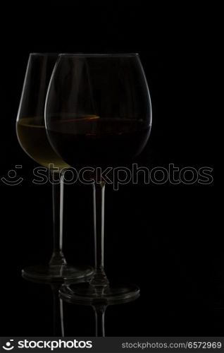 Wine glasses on black - two glasses of red and white wine. Wine glasses on black