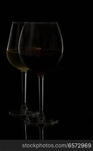 Wine glasses on black - two glasses of red and white wine. Wine glasses on black