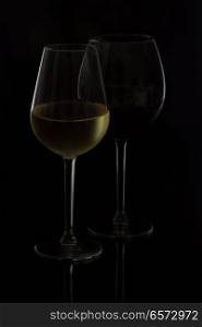 Wine glasses on black - two high glasses of red and white wine. Wine glasses on black