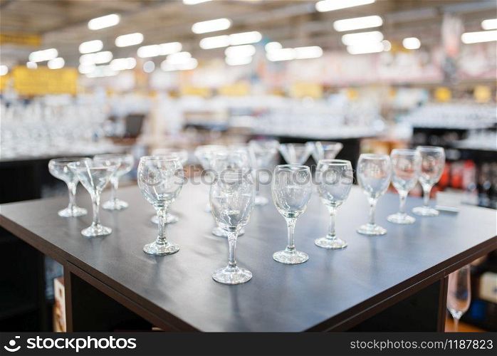 Wine glasses on the shelf closeup, houseware store, nobody. Home goods in market, kitchenware supply shop products. Wine glasses on the shelf closeup, houseware store