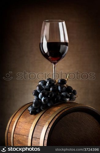 Wine goblet with wooden barrel and grape