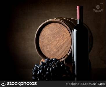Wine, grape and barrel on dark background