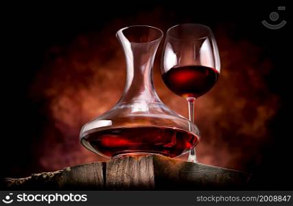 Wine in a decanter and glass on a wooden table. Wine in a decanter and glass