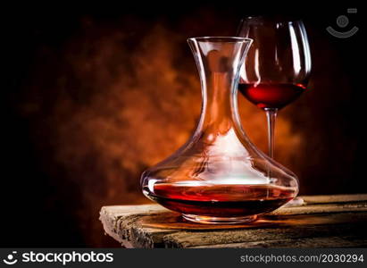 Wine in a decanter and glass on a wooden table. Wine in decanter and glass
