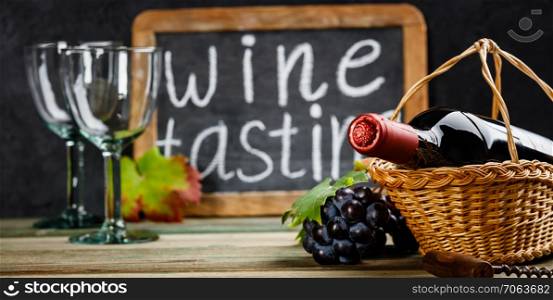Wine tasting concept. Wine in basket with grapes, leaves and corks on dark background, copyspace