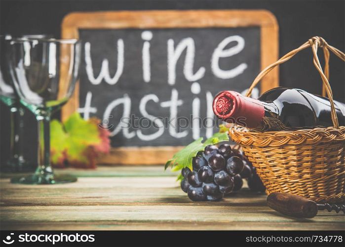 Wine tasting concept. Wine in basket with grapes, leaves and corks on dark background, copyspace. Wine composition on dark rustic background, space for text