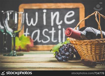 Wine tasting concept. Wine in basket with grapes, leaves and corks on dark background, copyspace. Wine composition on dark rustic background, space for text