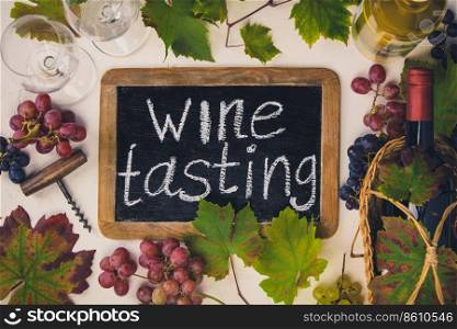 Wine with glasses, grapes, leaves and corkscrew on dark background, copyspace, flat lay. Wine composition on rustic background, flat lay, top view