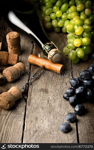 Wine with grape and corks on wooden table