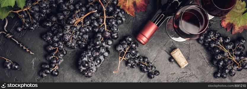 Wine with grapes, leaves and corks on dark background, copyspace, flat lay. Wine composition on dark rustic background, flat lay