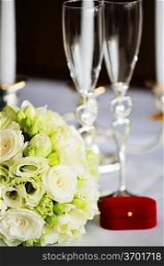 wineglass and wedding bouquet on table