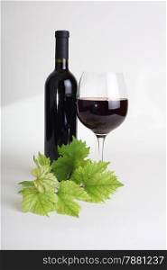 wineglass, bottle of wine and grapes leaf