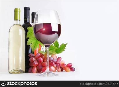 wineglass, bottles of wine and grapes