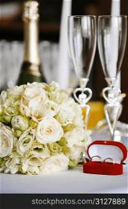 wineglass, candles and wedding bouquet on table