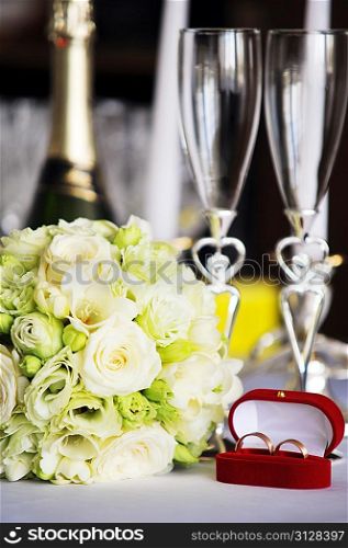 wineglass, candles and wedding bouquet on table