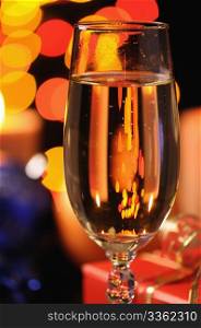 Wineglass with a champagne on a background of multicoloured sparks